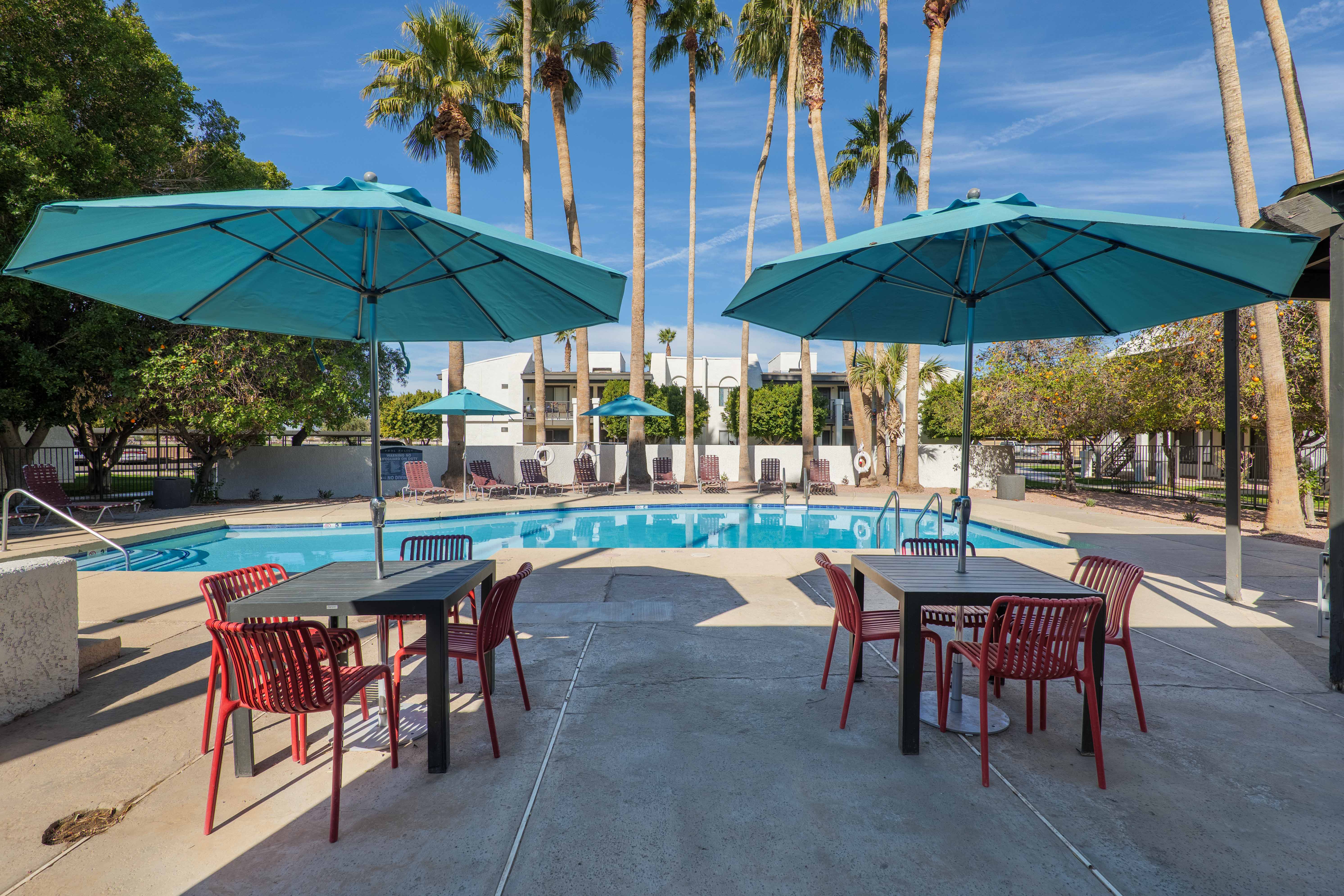 Poolside tables and chairs with umbrellas