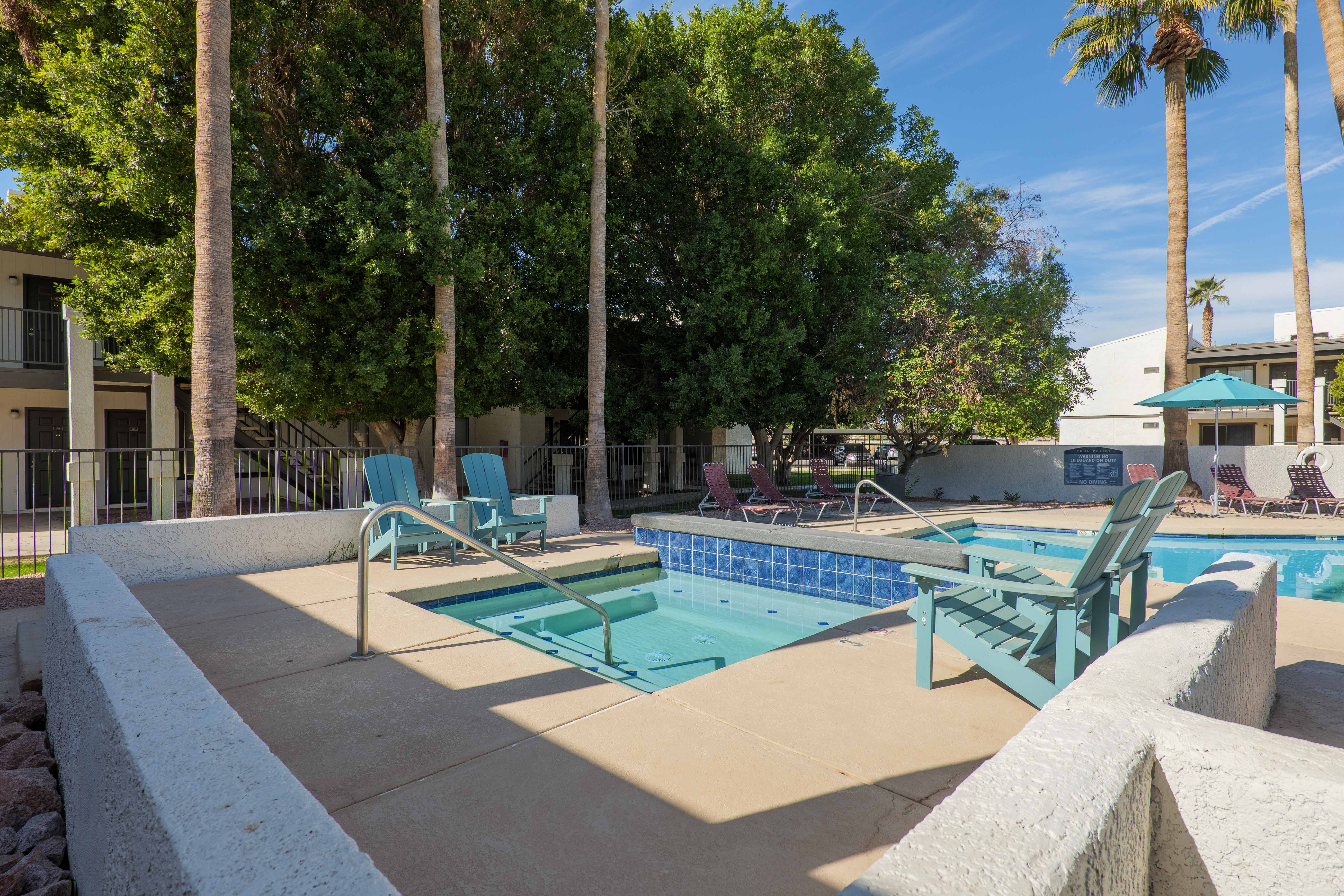 Poolside spa with blue lounge chairs