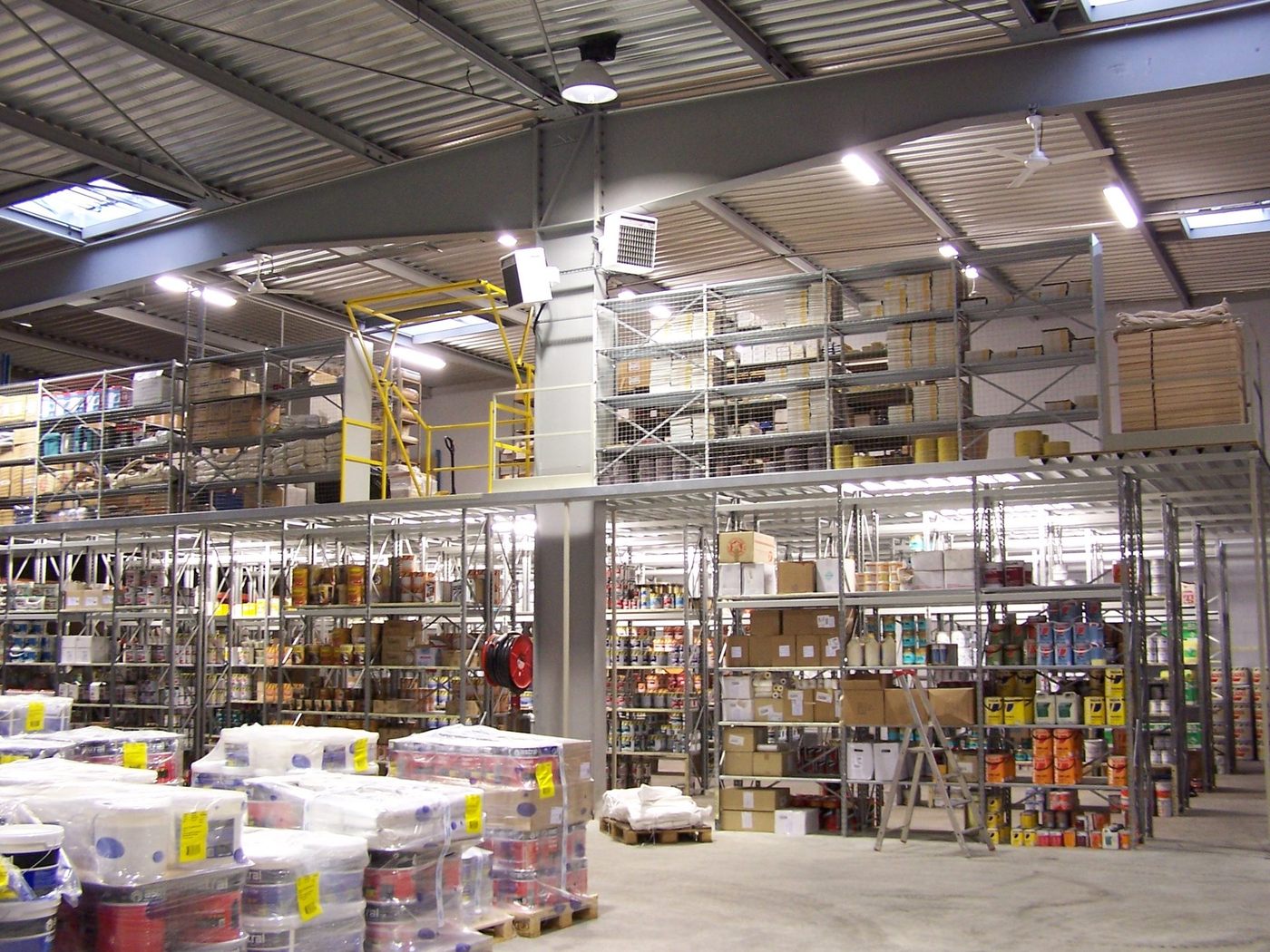 Magasin de négoce équipé de rayonnage mi-lourd chargé de références, zone de picking en exploitation