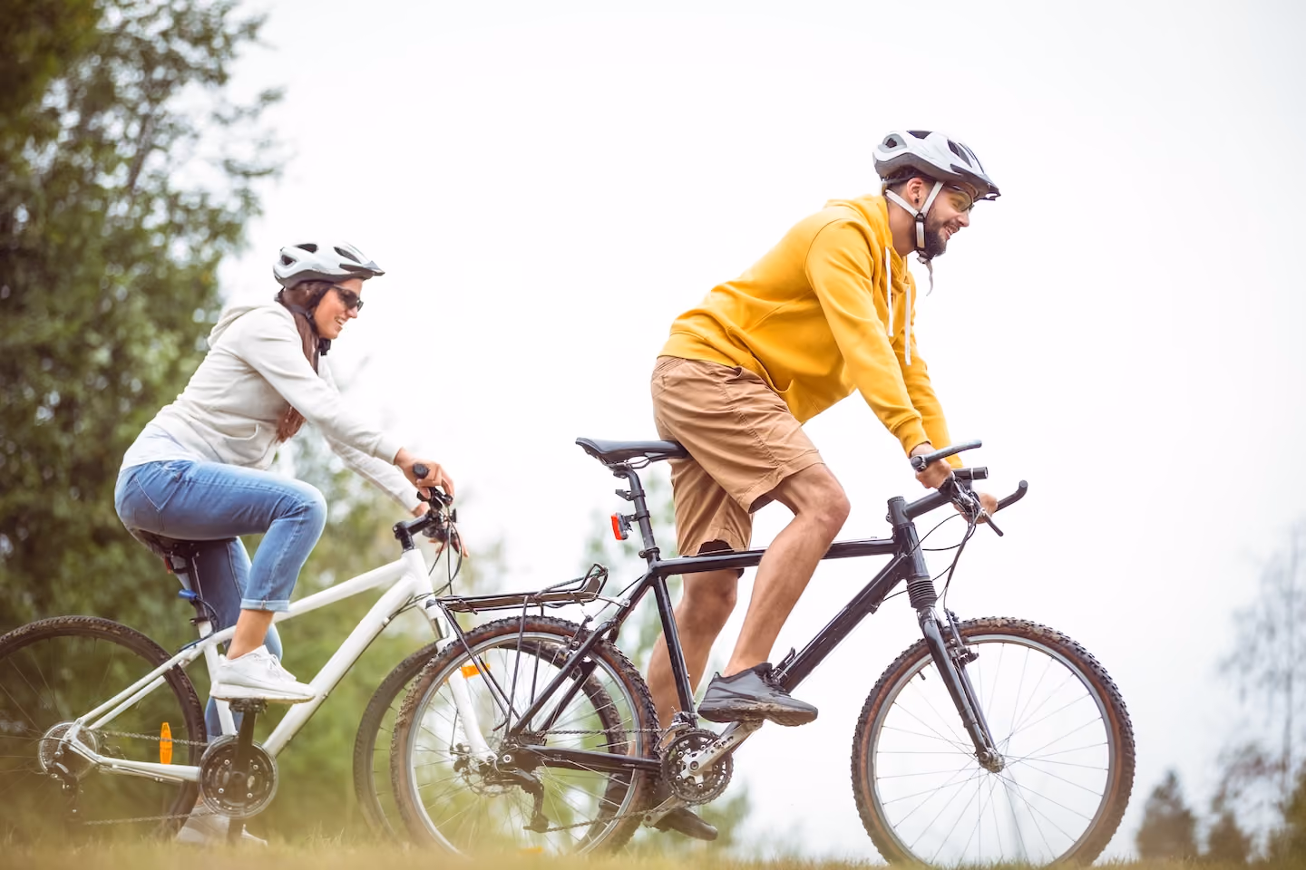 Couple riding bikes with helmets