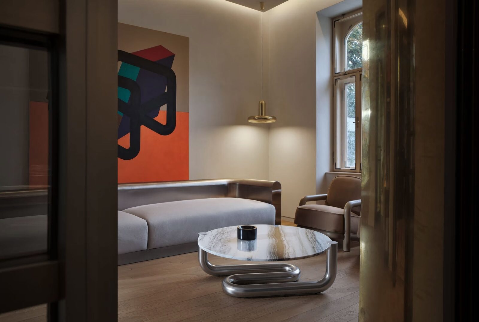 TC Studio lounge with stainless steel bench, tubular steel coffee table and brass pendant