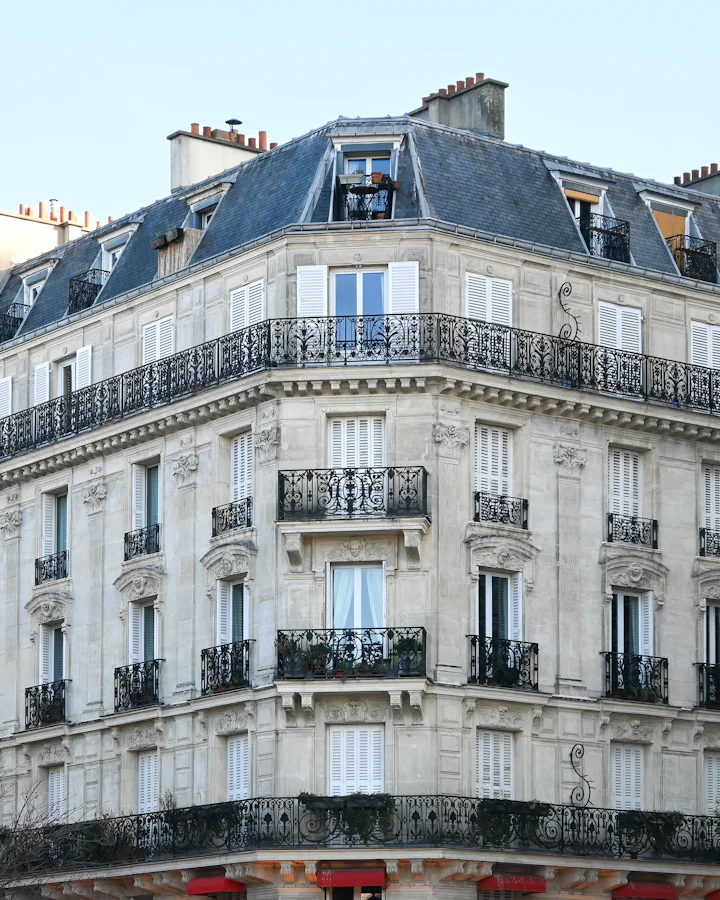 Immeuble haussmannien en pierre de taille avec balcons en fer forgé