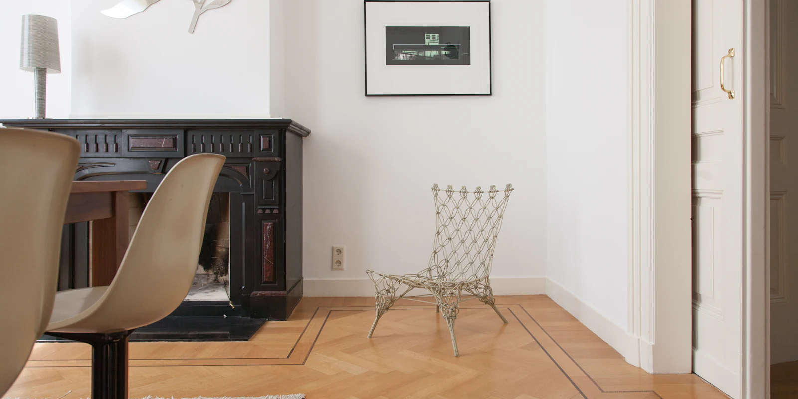 Séjour d’un appartement haussmannien : parquet à bâtons rompus, cheminée et lumière naturelle