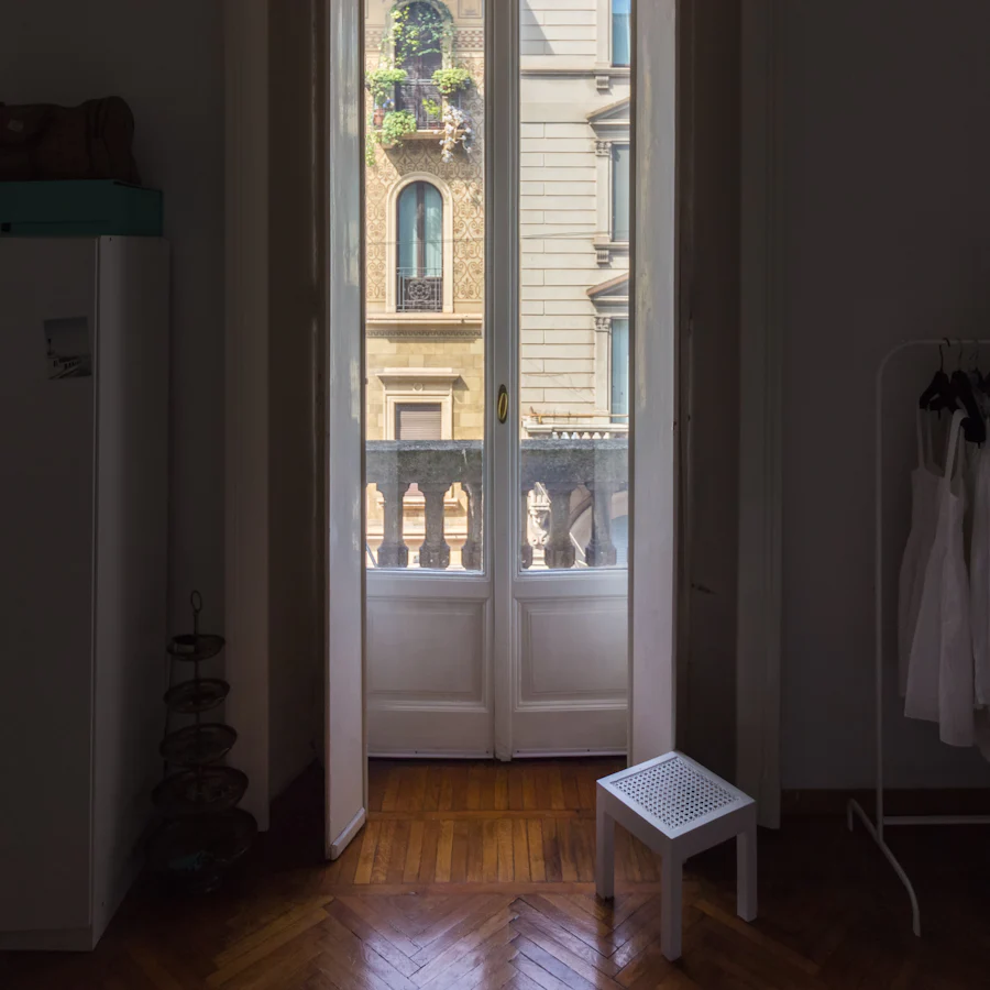 Porte-fenêtre ouverte sur un balcon en pierre, parquet en point de Hongrie