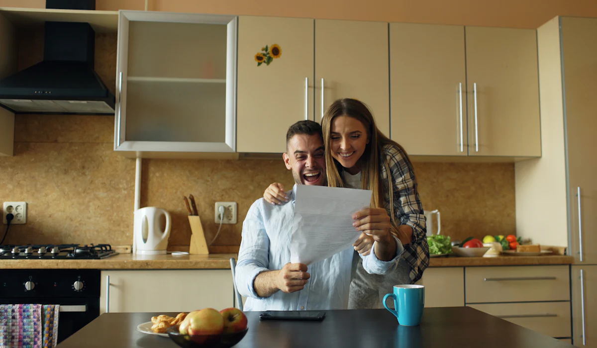 Couple de propriétaires lisant un document dans leur cuisine