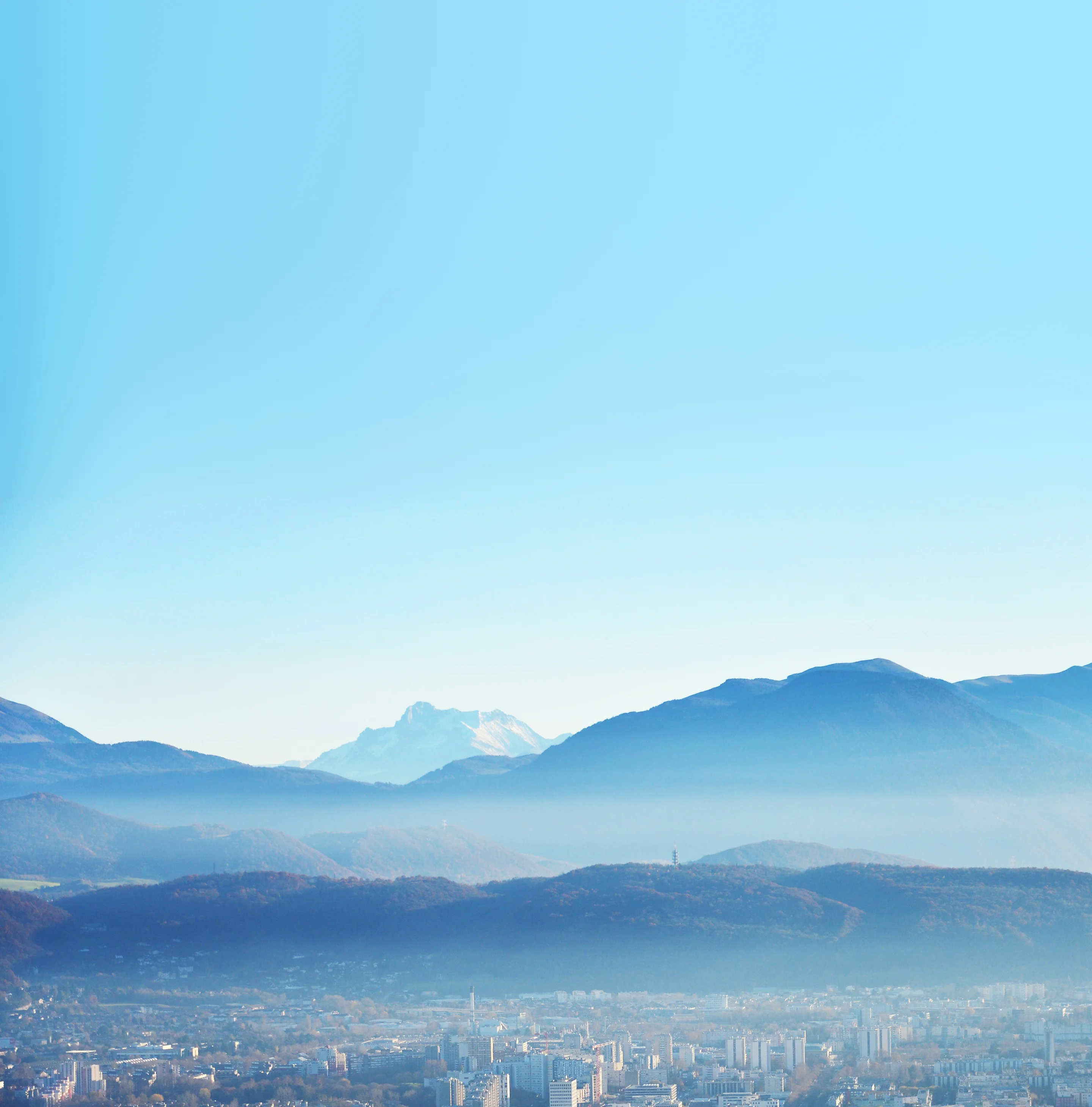 Grenoble au pied des montagnes, sous un ciel bleu clair