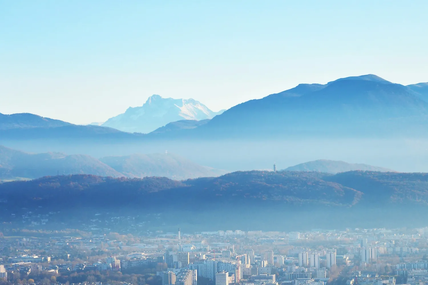 Grenoble au pied des montagnes, sous un ciel bleu clair