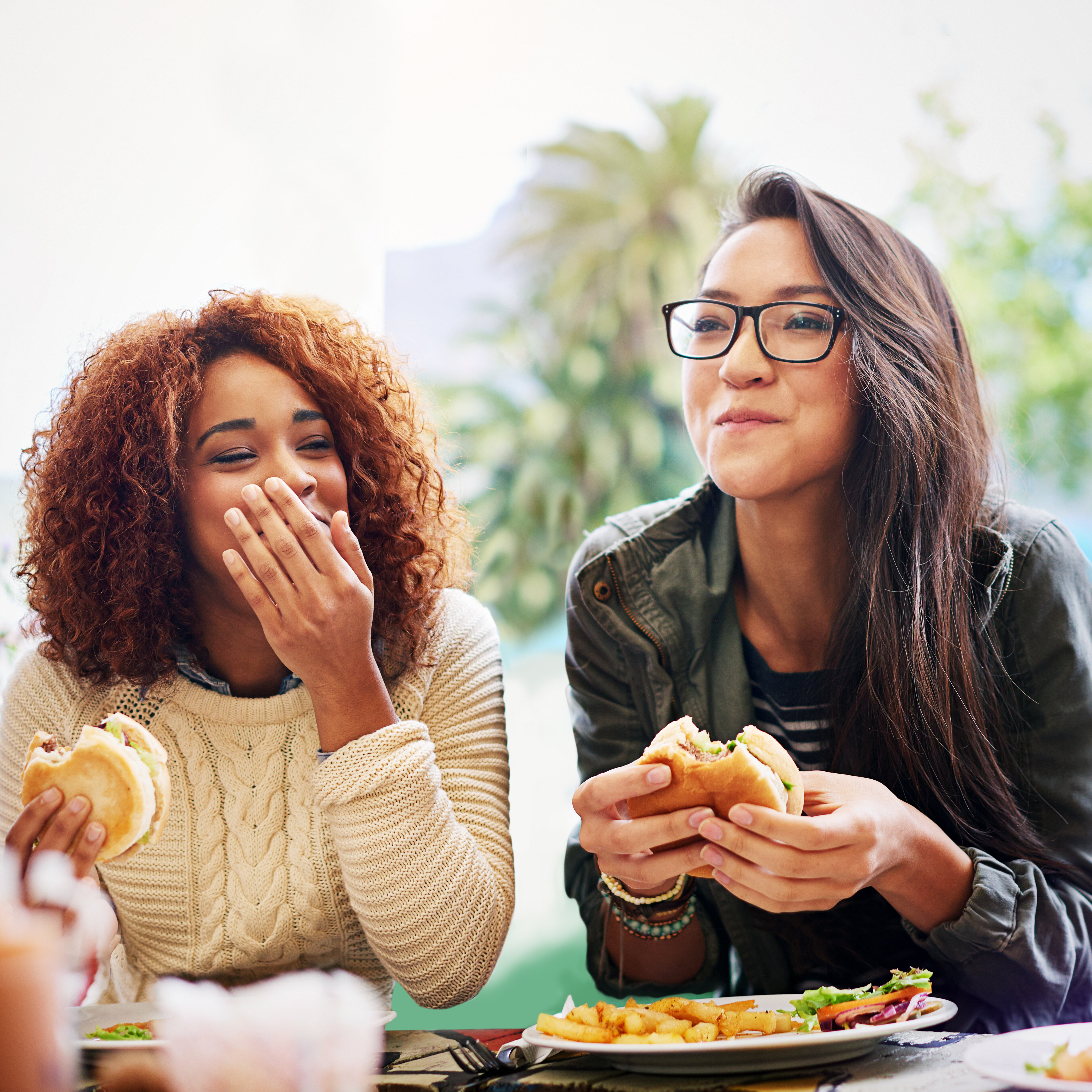 two girls eating burgers stock image