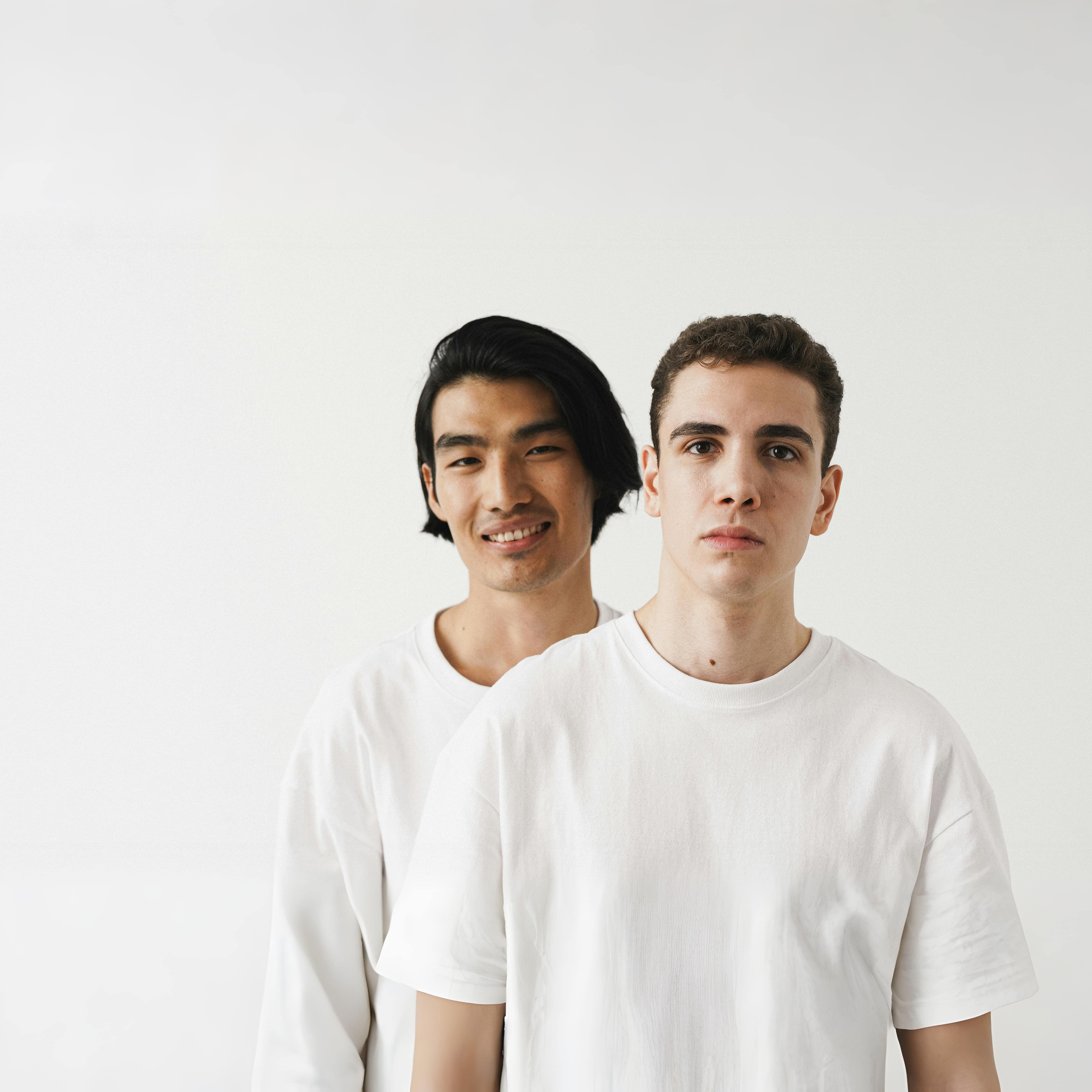 Close-Up Shot of Two Men Wearing White Shirt on White Background
