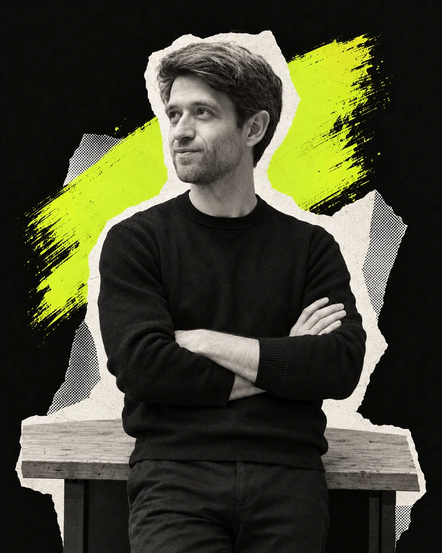 Michel, oprichter van weeks.work, met gekruiste armen tegen een bureau, kijkend naar zijn verhaal.