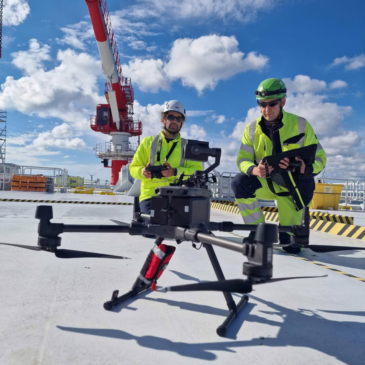 Zwei Techniker von mh² inspection mit Inspektionsdrohne auf dem Deck einer Offshore-Plattform