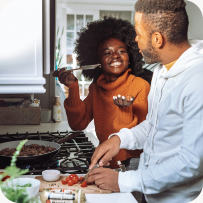 Two people cooking together at a stovetop