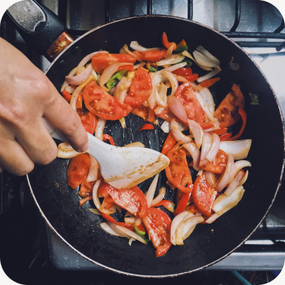 Tomatoes and onions cooking in a skillet