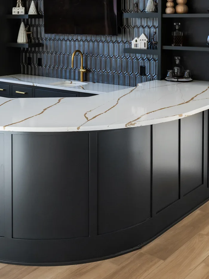 Curved black bar cabinetry with a gold-veined quartz countertop