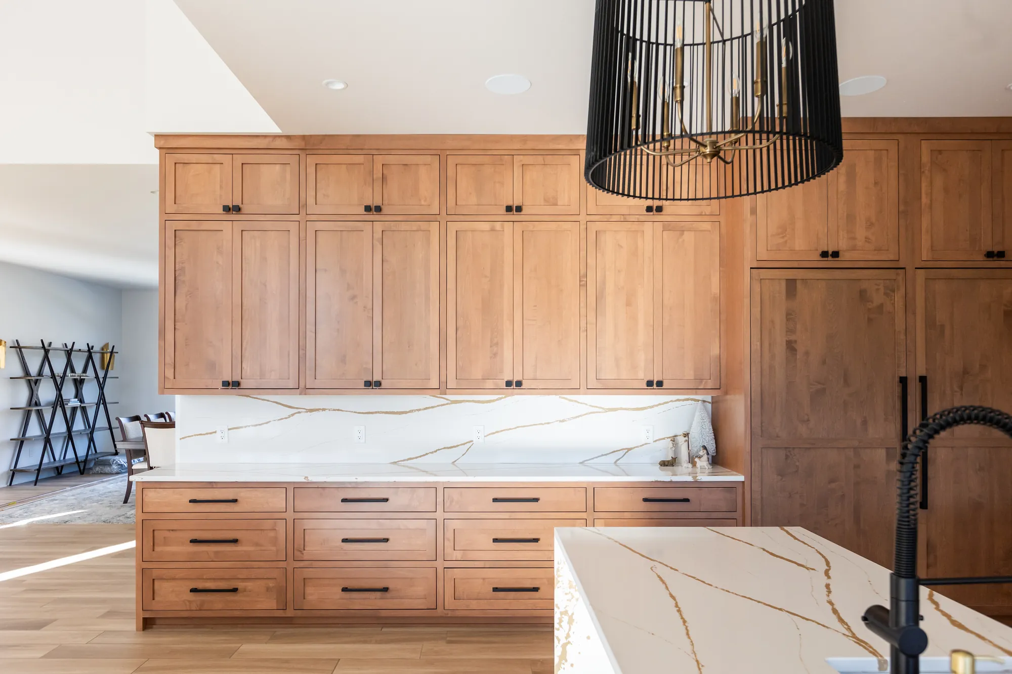 Knotty alder kitchen cabinetry with a quartz island and full-height pantry cabinets