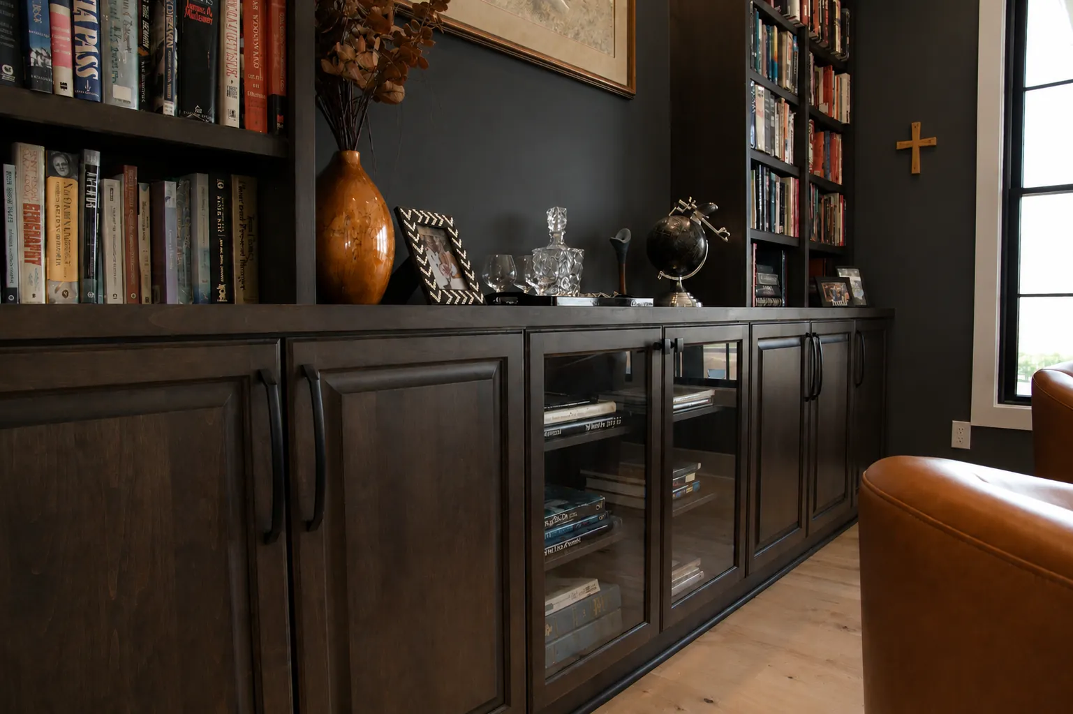 Dark stained study built-in cabinets with glass doors and bookshelves