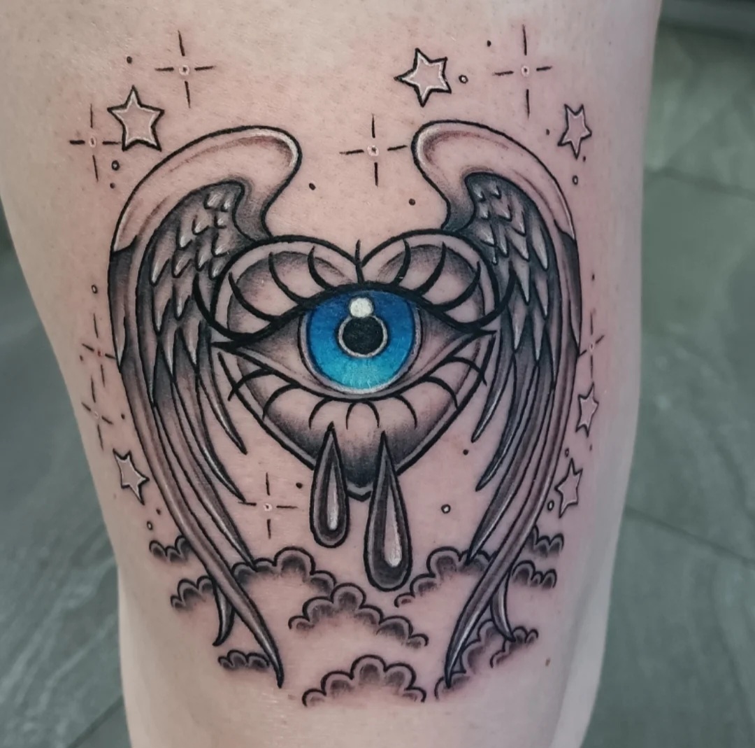 Winged blue eye tattoo by Ramona at Lady Ink