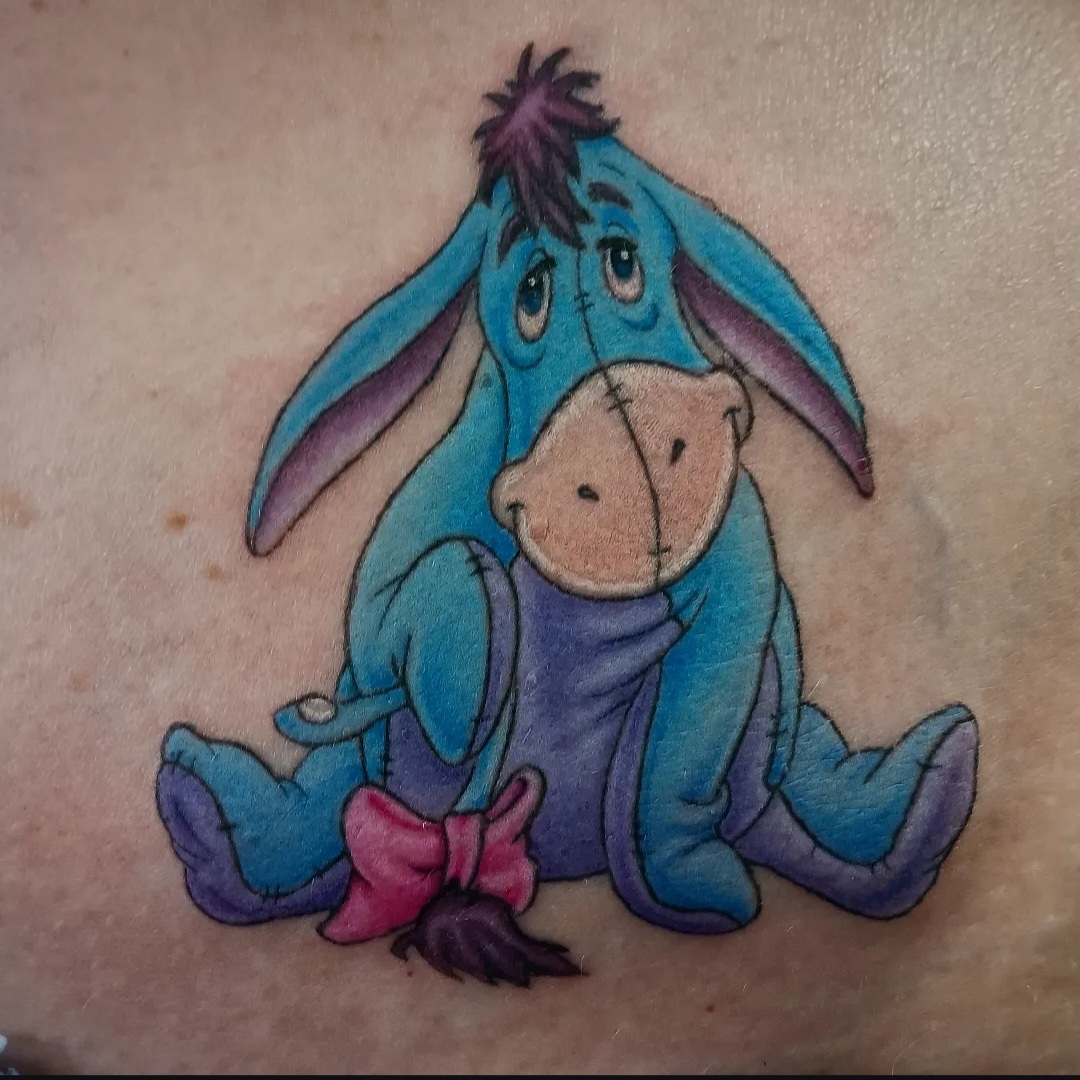 Colourful Eeyore character tattoo by Ramona at Lady Ink