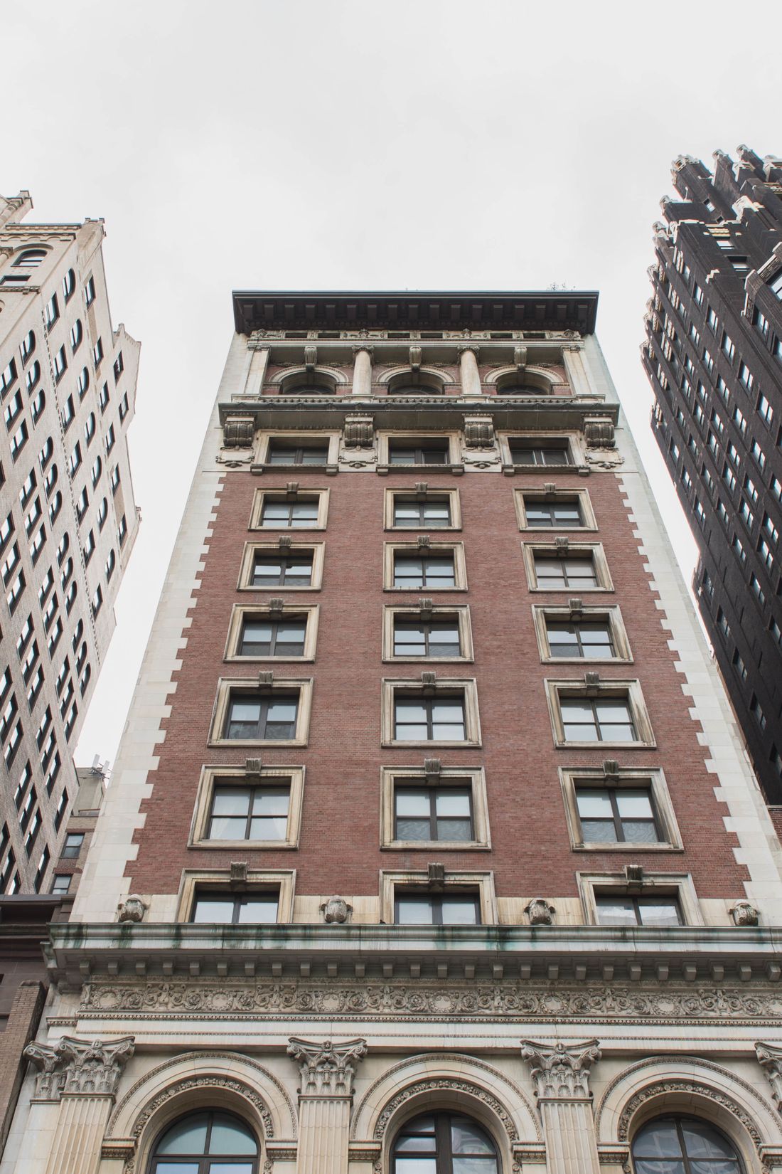 Prewar New York City building facade between Manhattan towers
