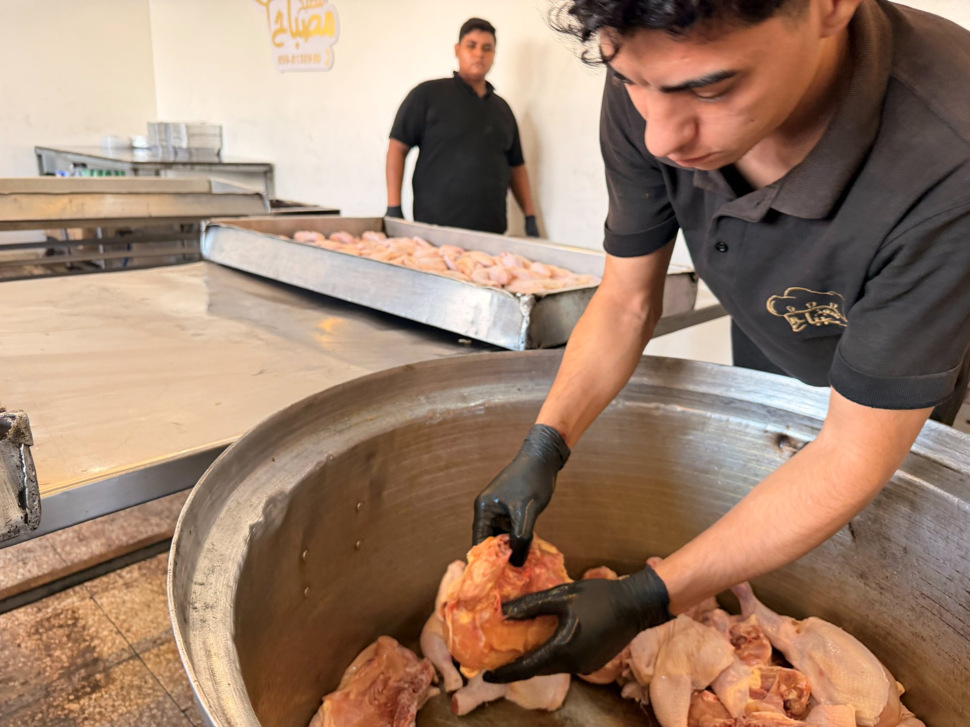 FAJR Global staff preparing chicken for meal distribution