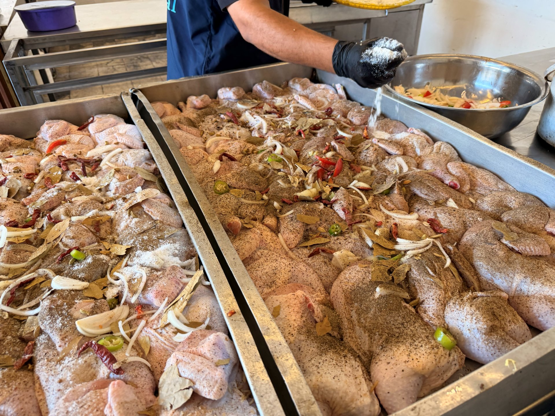 Seasoning chicken for the community kitchen in Gaza
