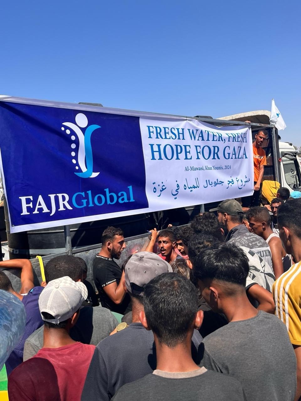 Families gathering at a FAJR Global clean water distribution in Gaza
