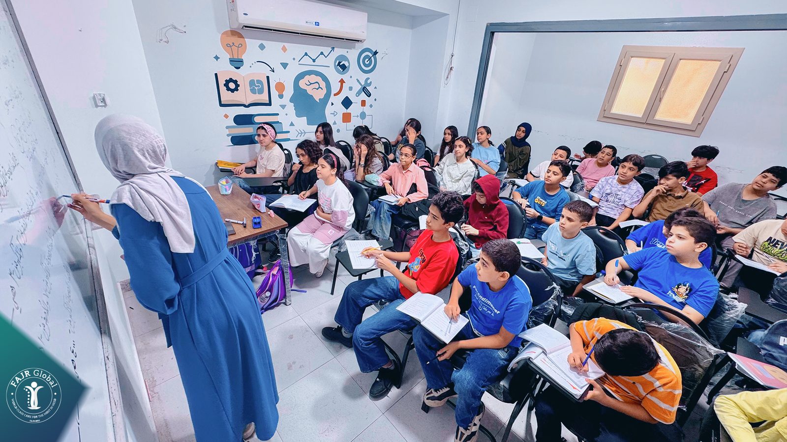A teacher at the whiteboard in a full classroom of Palestinian students