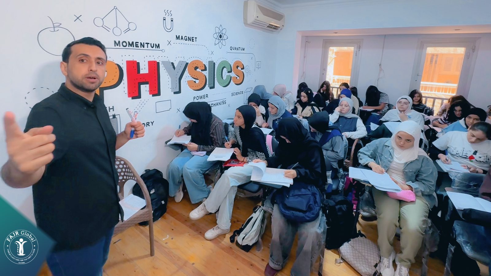 A teacher leading a physics lesson for Palestinian students in Cairo