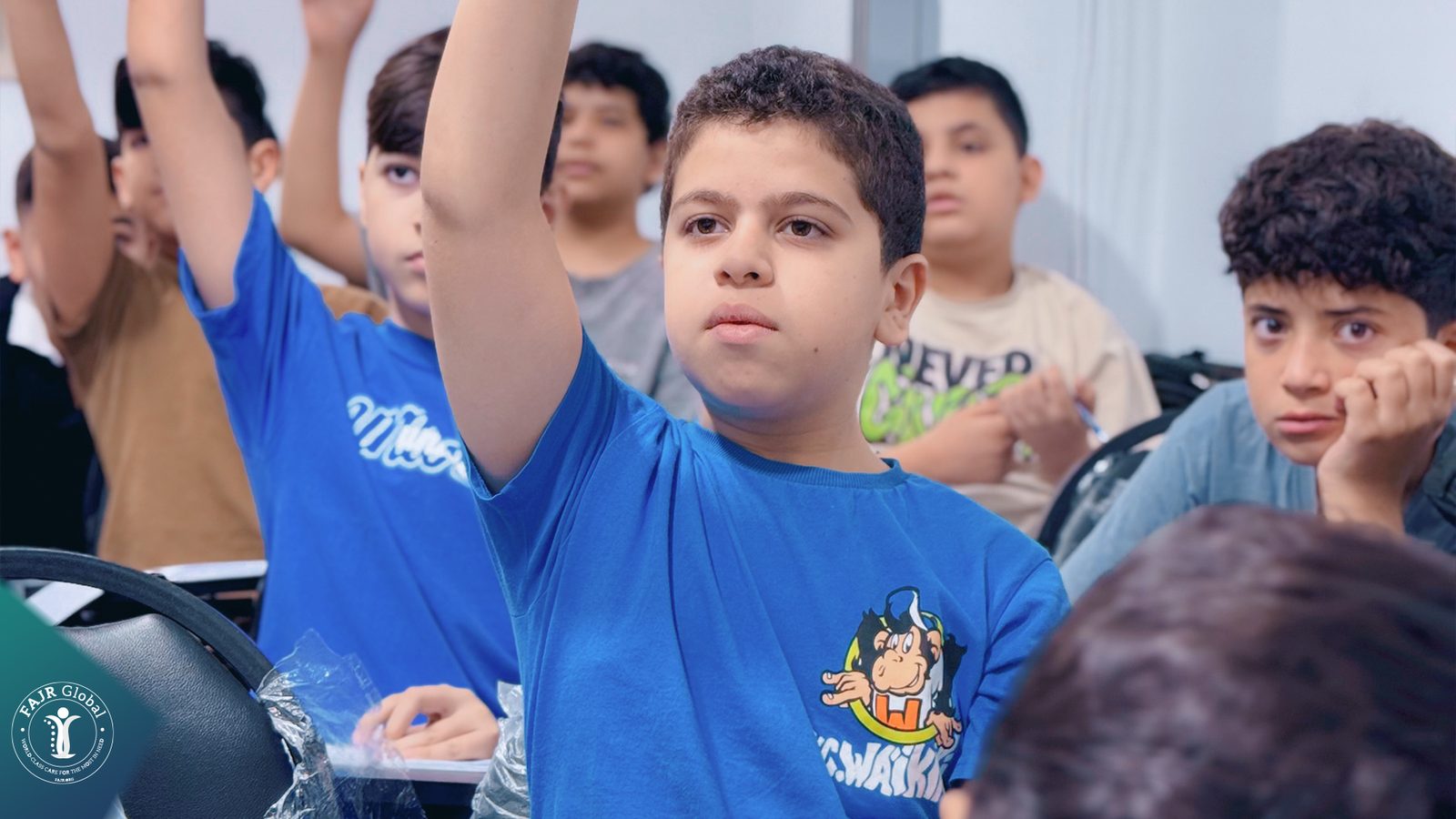 Boys raising their hands to answer a question
