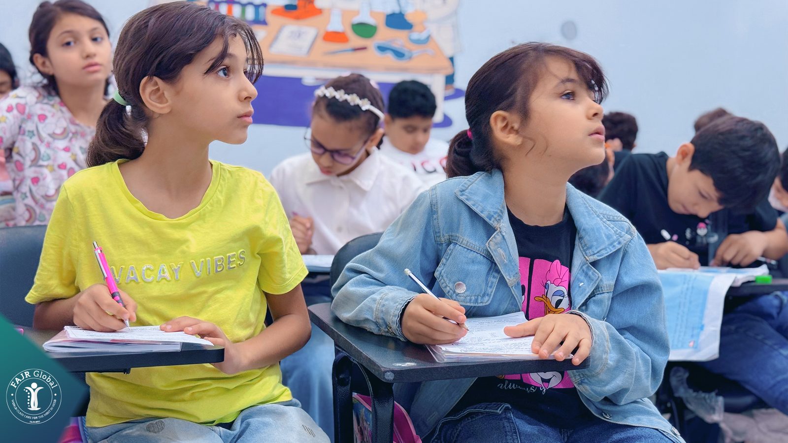 Palestinian girls writing in their notebooks during a lesson