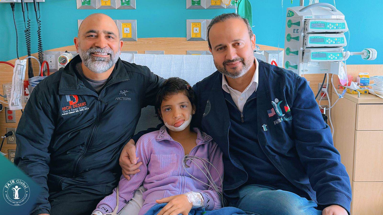 Two doctors sit with a young girl in her hospital room