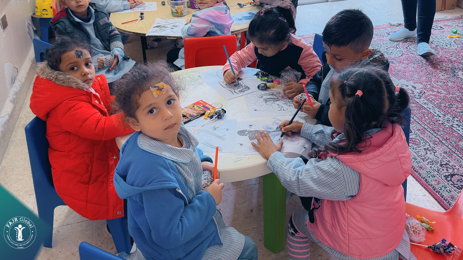 Children drawing and colouring at a round table