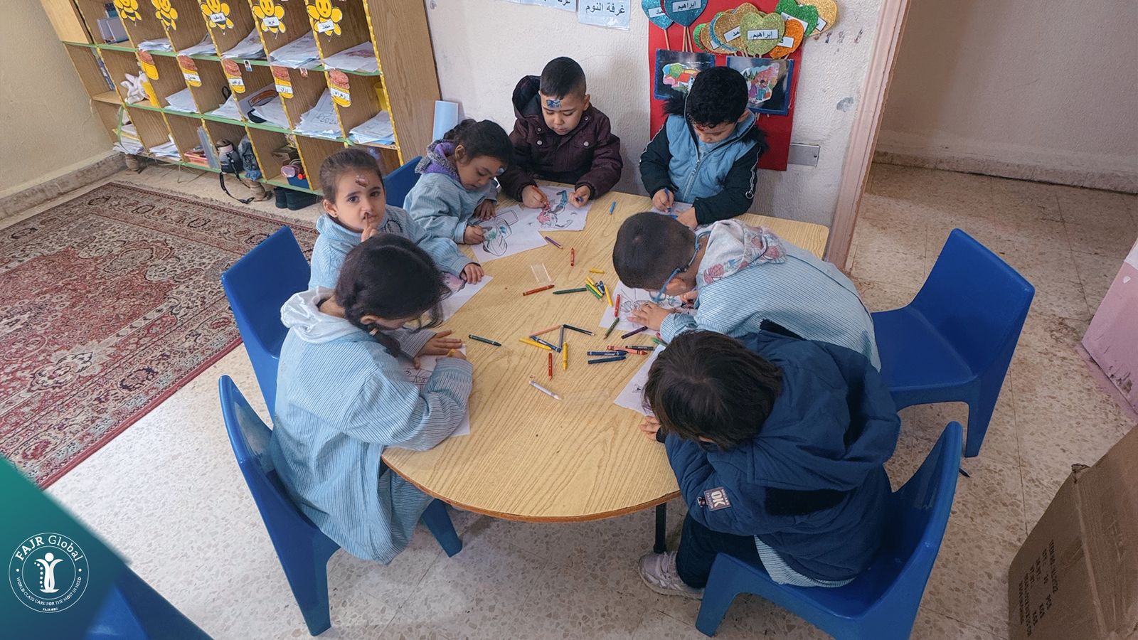 Children colouring at a round table during an activity session