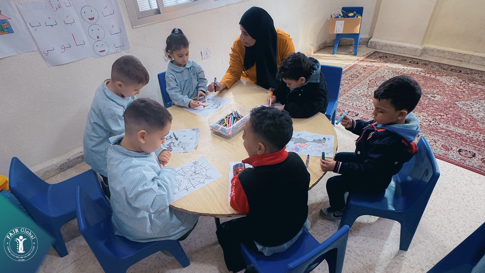 A teacher sitting with children as they colour
