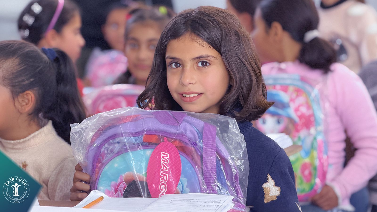 A girl at her desk holding a new school backpack
