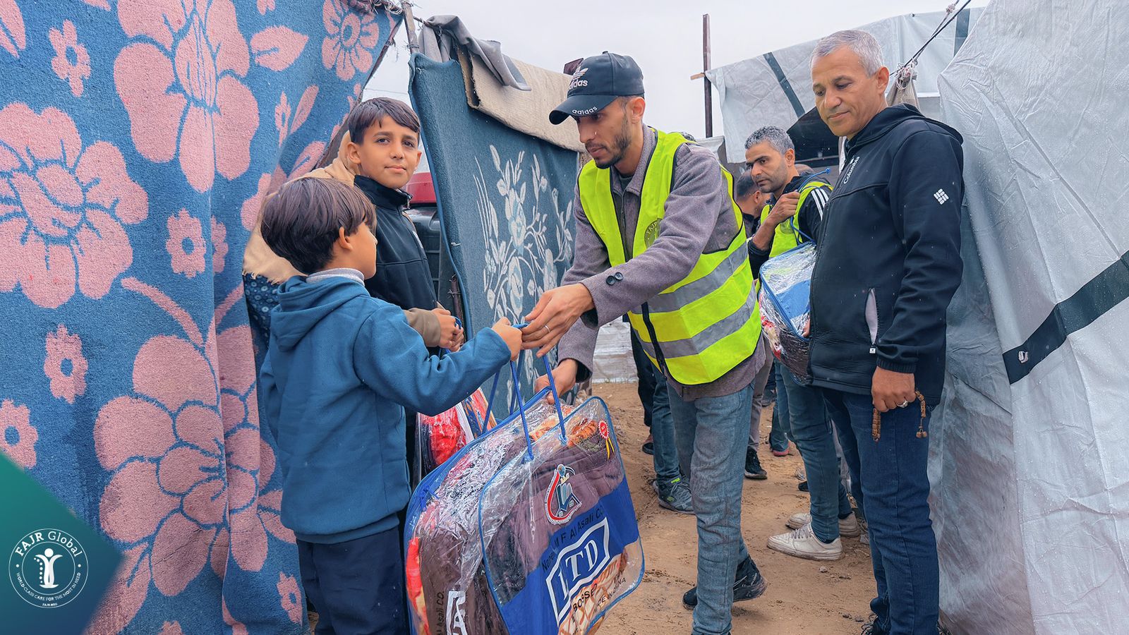 FAJR Global volunteers handing out winter blankets to children