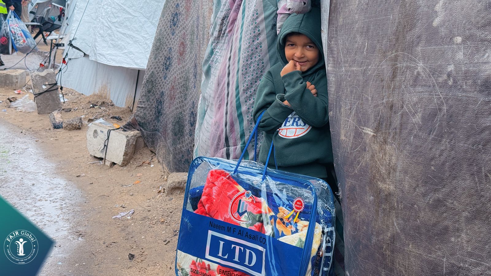 A child peeks out of a tent next to a winter blanket bag