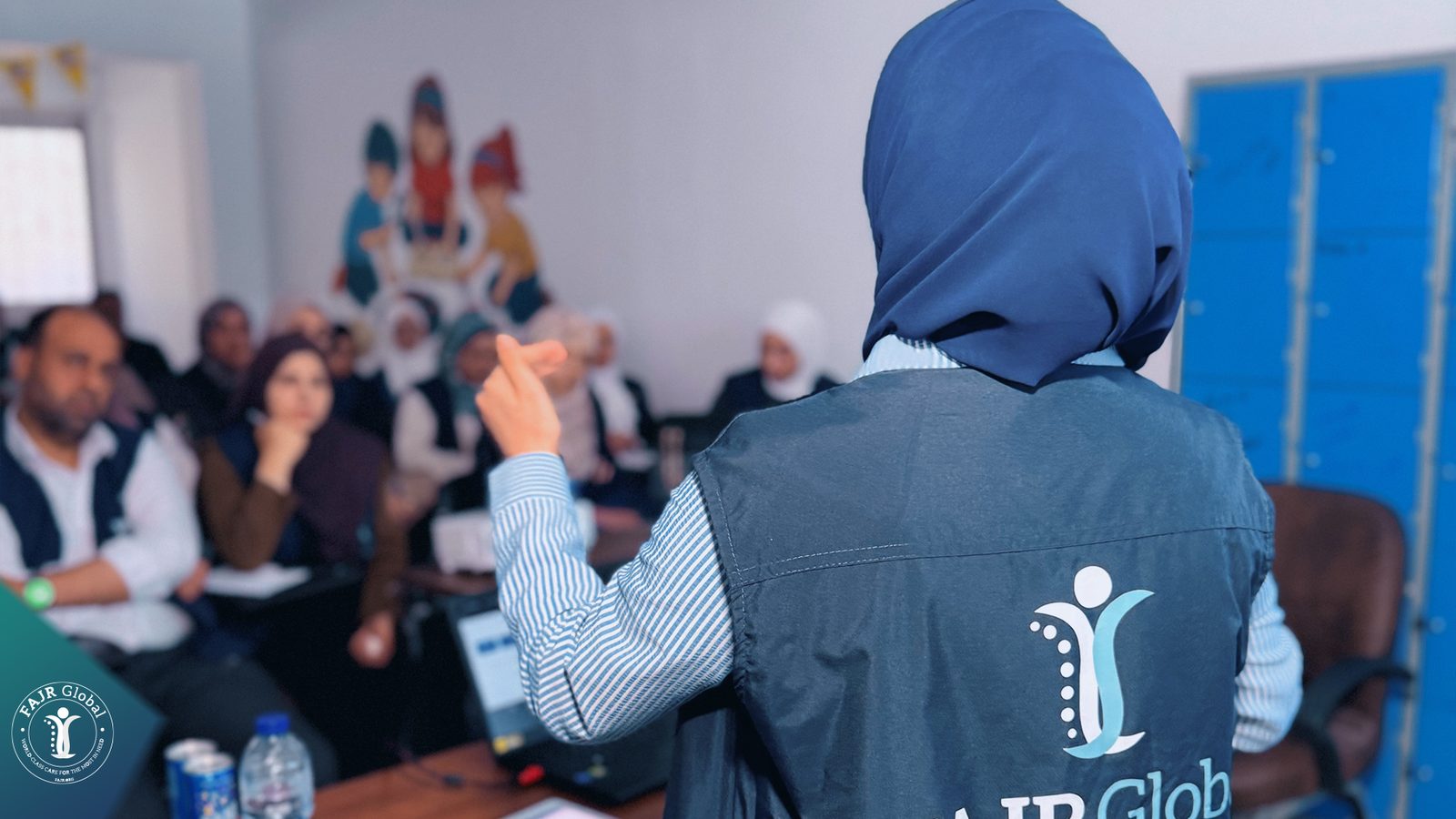 A FAJR Global staff member speaking to colleagues during a group discussion at the workshop