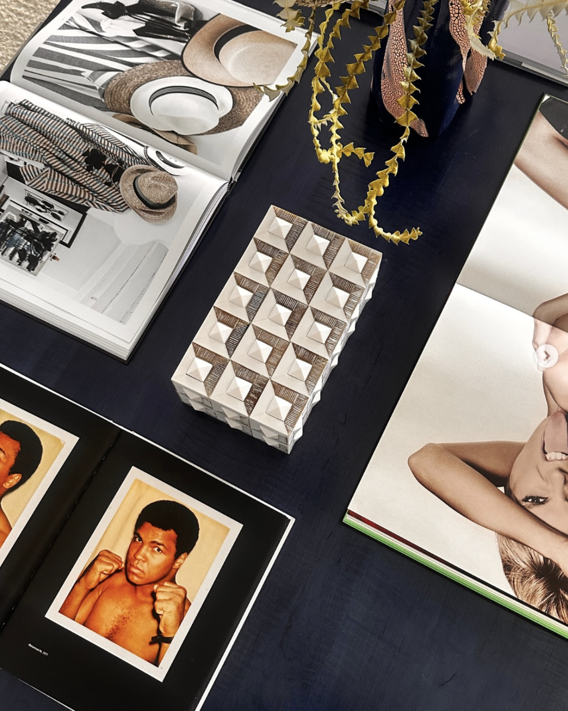 Art and design books with decorative objects on a table.