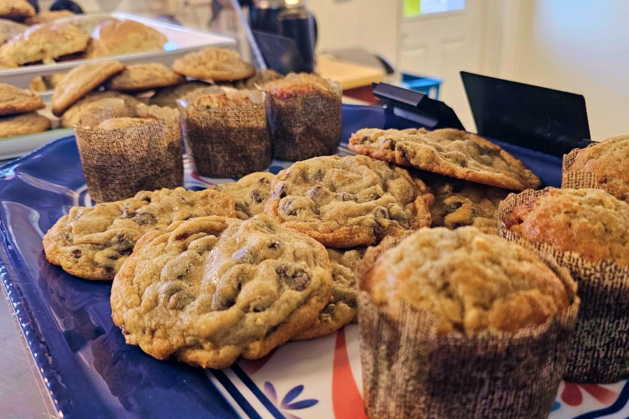 Bakery counter stocked with muffins, cookies, and scones.