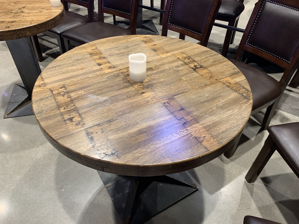 Round restaurant table with a reclaimed hardwood top.