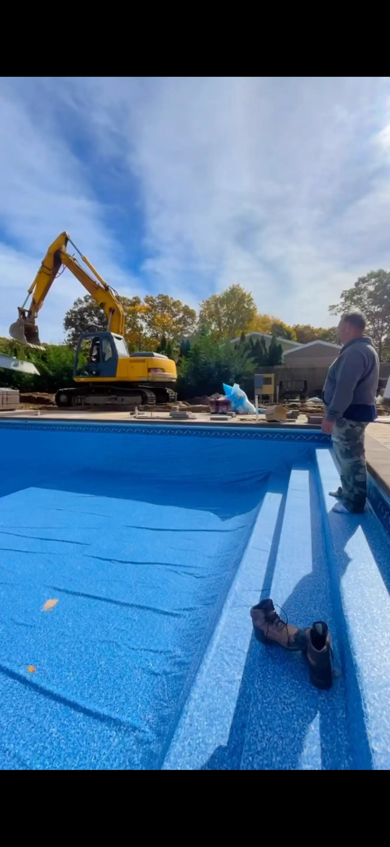 In-ground swimming pool undergoing renovation with a new blue liner.