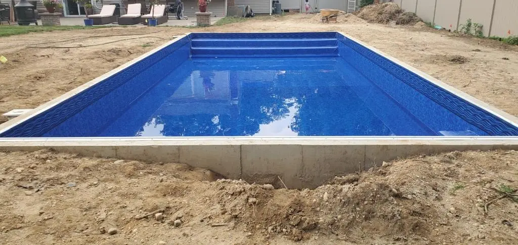New in-ground swimming pool in the Hamptons with blue liner and built-in steps during construction.