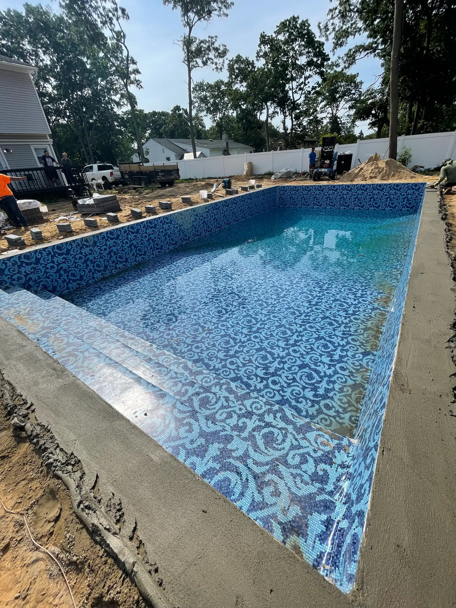 Pool renovation in progress with new blue patterned liner and surrounding concrete work in the Hamptons.