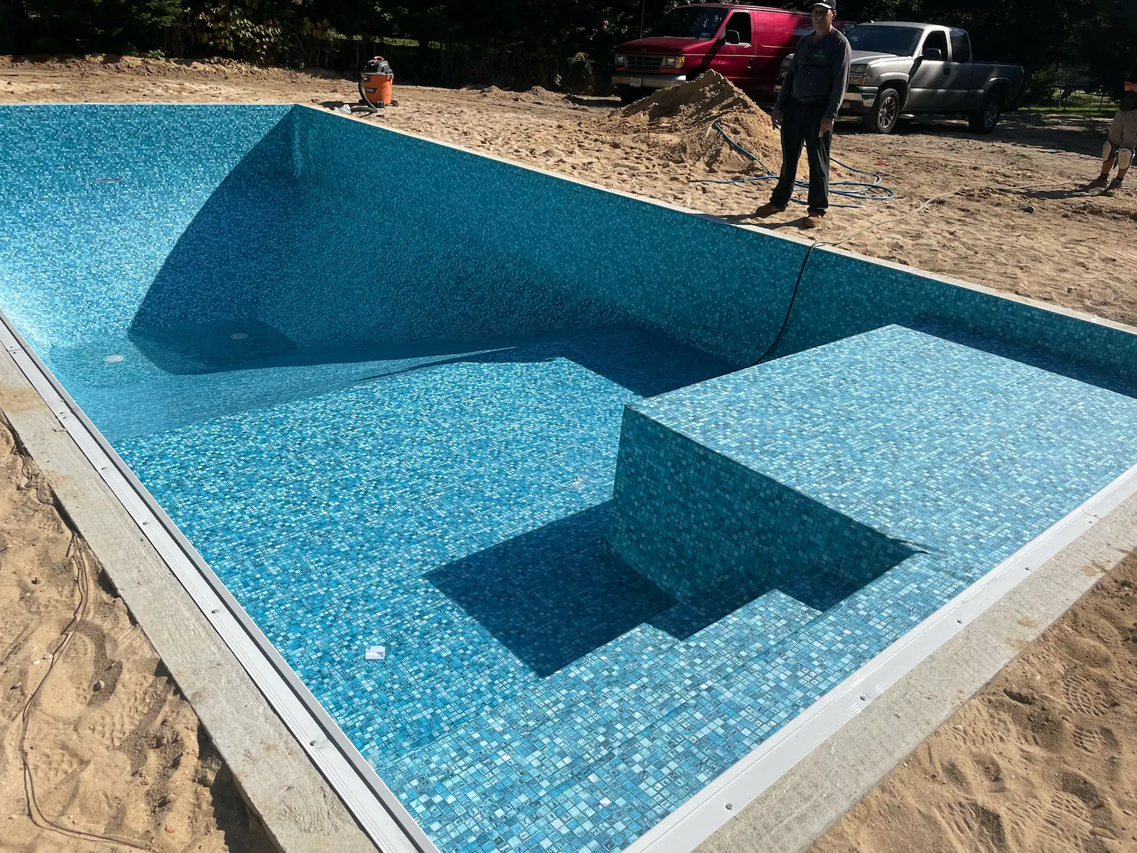Pool renovation in progress with new blue mosaic liner and built-in tanning ledge on Long Island, NY.