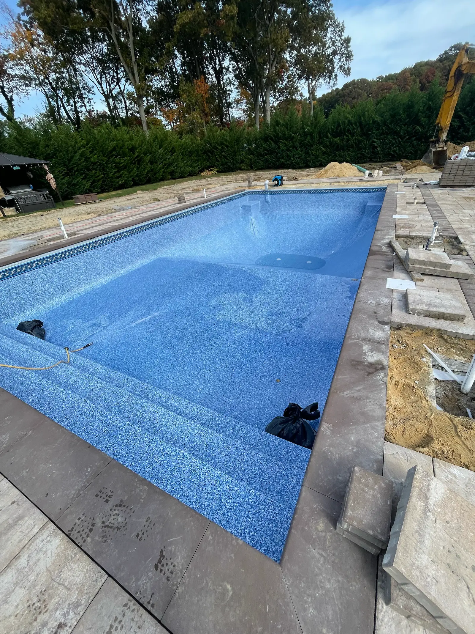 Renovated in-ground pool with new blue mosaic liner and built-in steps on Long Island, NY.