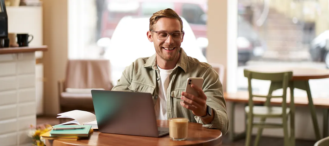 Freelancer usando su celular en una cafetería