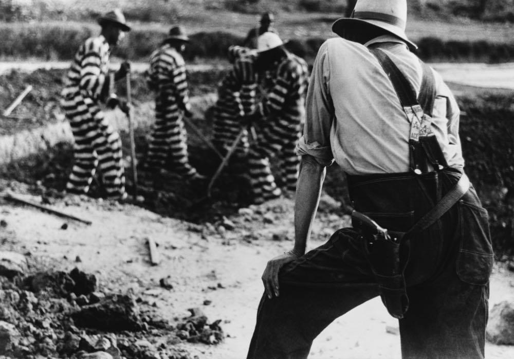 Black and white photo of a prison chain gang working outdoors