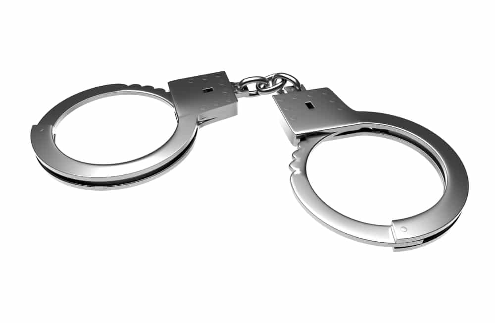 Pair of metal handcuffs on a white background