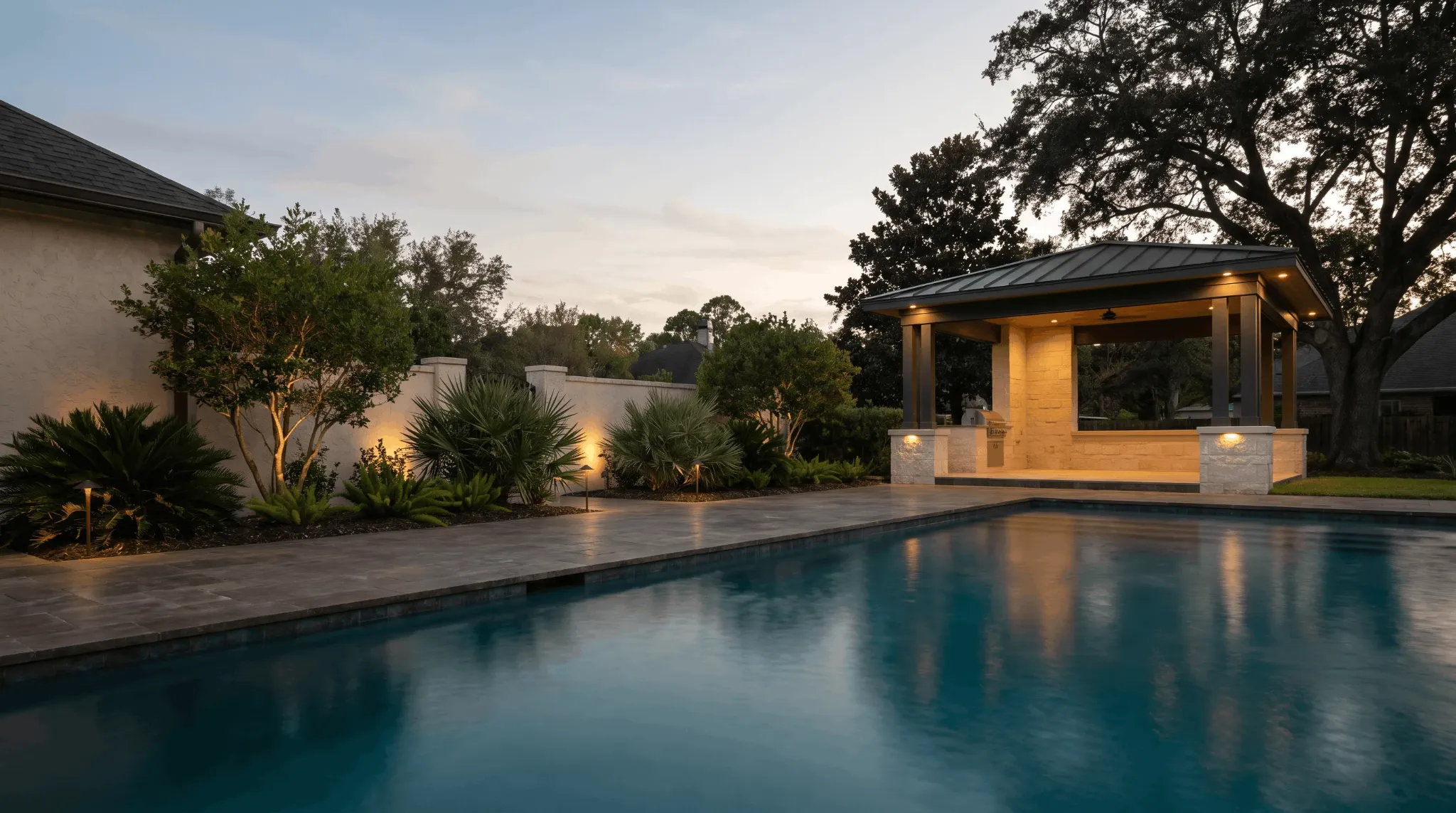 Illustrative dusk view with selected garden accents and a lit pavilion beside a pool.